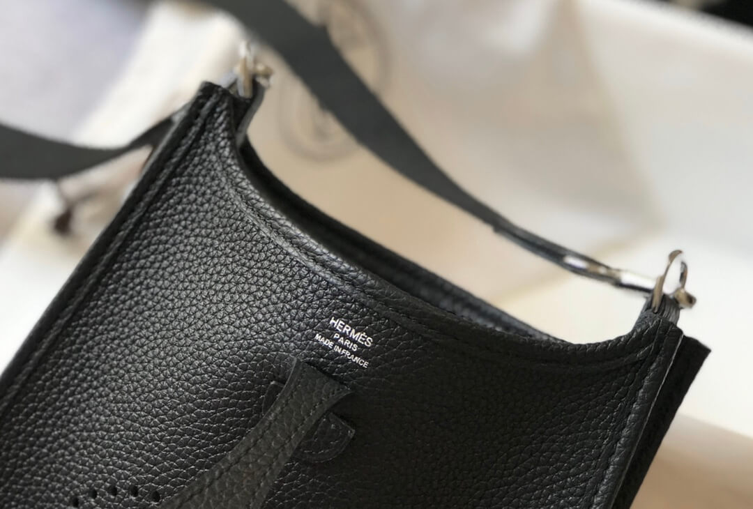 silver letter logo on the black leather bag